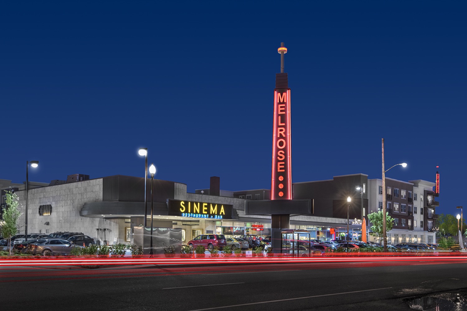 Melrose streetscape with the neighborhood marquee and cinema on 8th Avenue South at night.