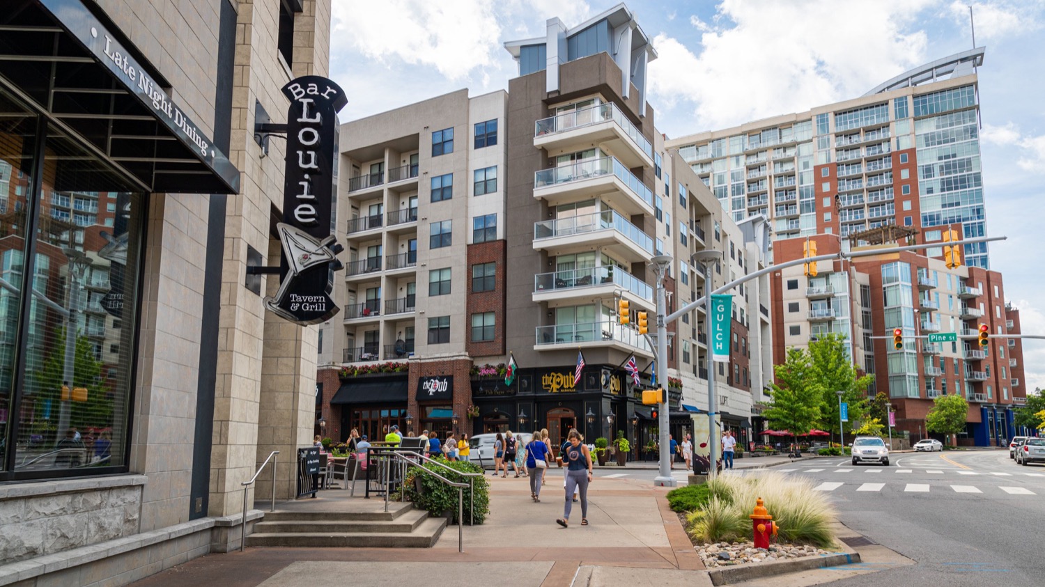 Walkable Gulch streetscape with high-rise residences, restaurants, and pedestrians in Nashville.